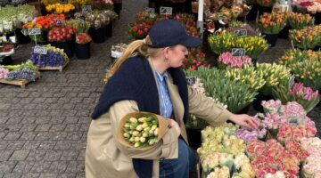 meisje gehurkt bij bloemenkraam