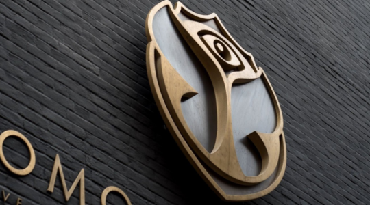 De voorgevel van het Tomorrowland-kantoor gefotografeerd, waarbij de focus is gelegd op het iconische festivallogo en kenmerkende vlinders die hierbij horen.