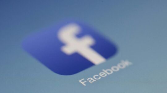 Het Facebook logo op een telefoon. Het bedrijf waar Evaldas Rimsauskas van stal